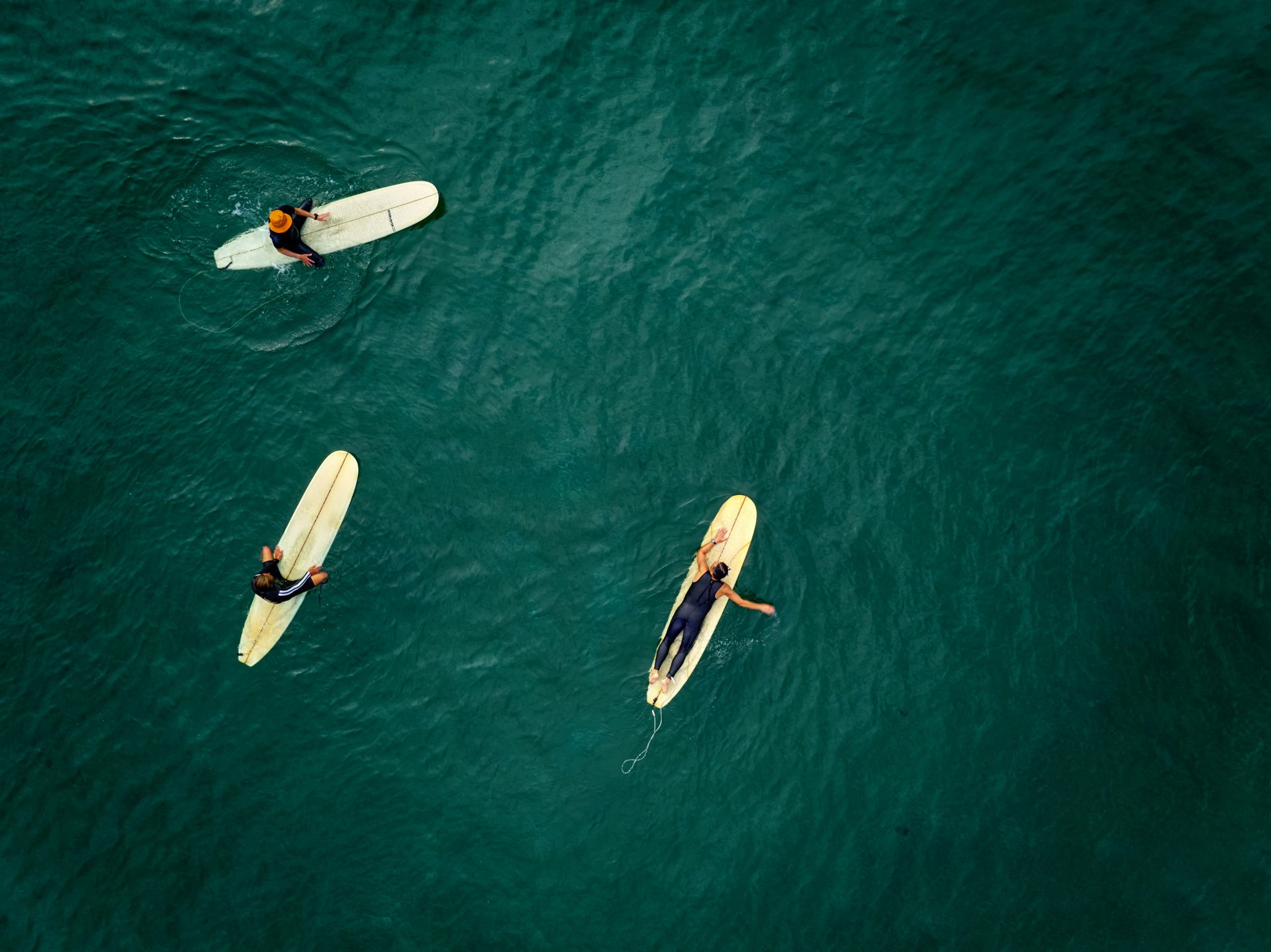 Surfers waiting together in the lineup A shared lineup runs on respect, not signs. Photo: Buddy An / Unsplash